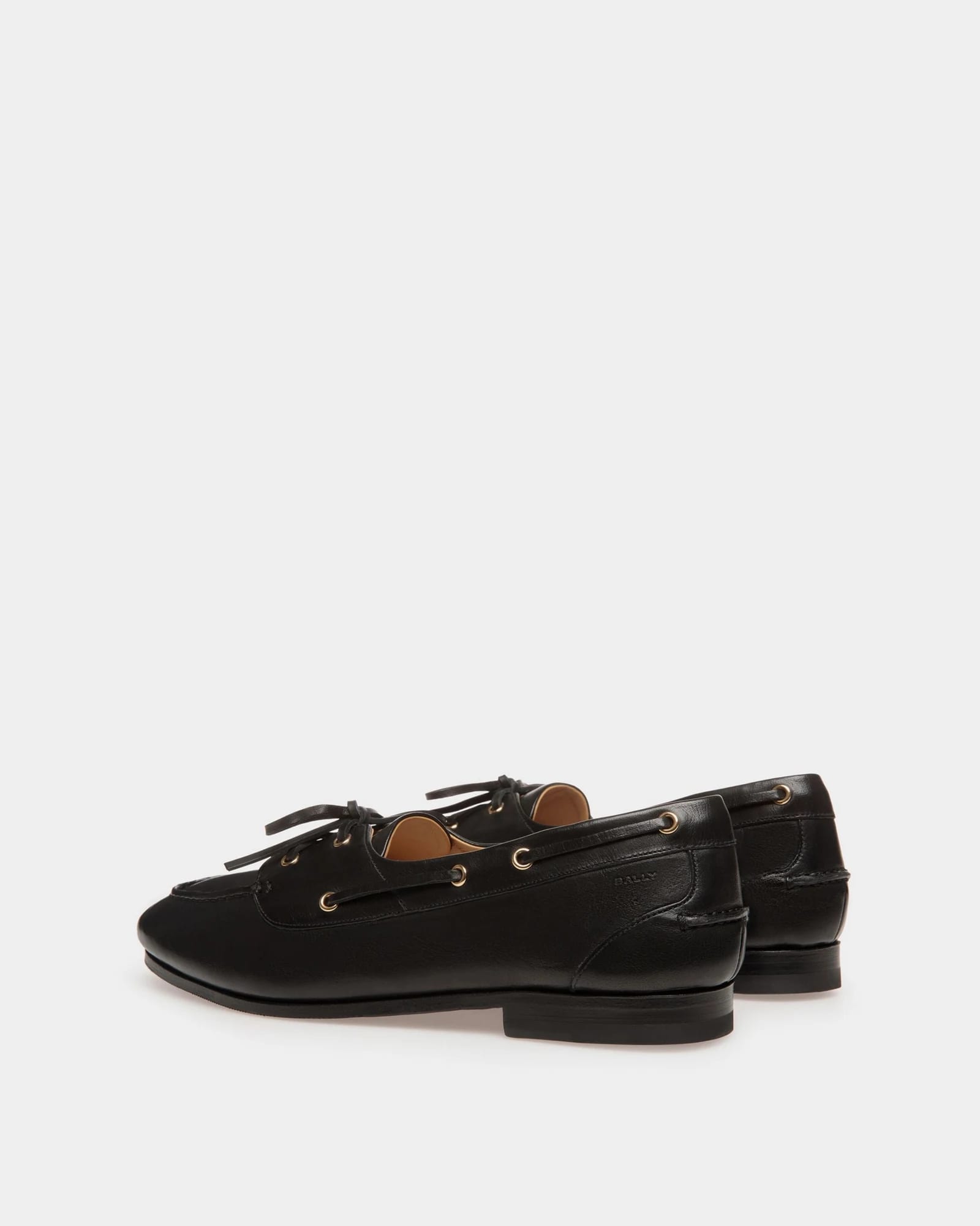 A pair of Bally black leather boat shoes with gold eyelets
