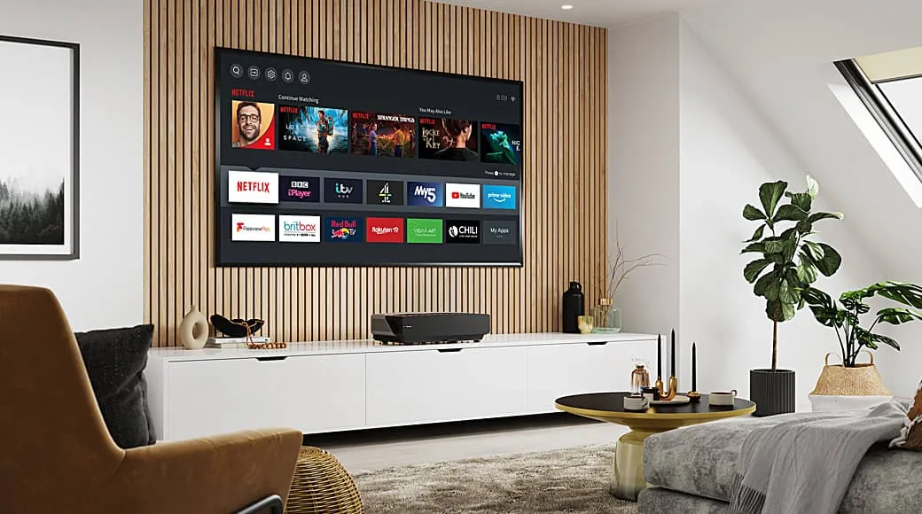 A large smart TV showing its home menu on a slatted oak wall in a bright loft living room
