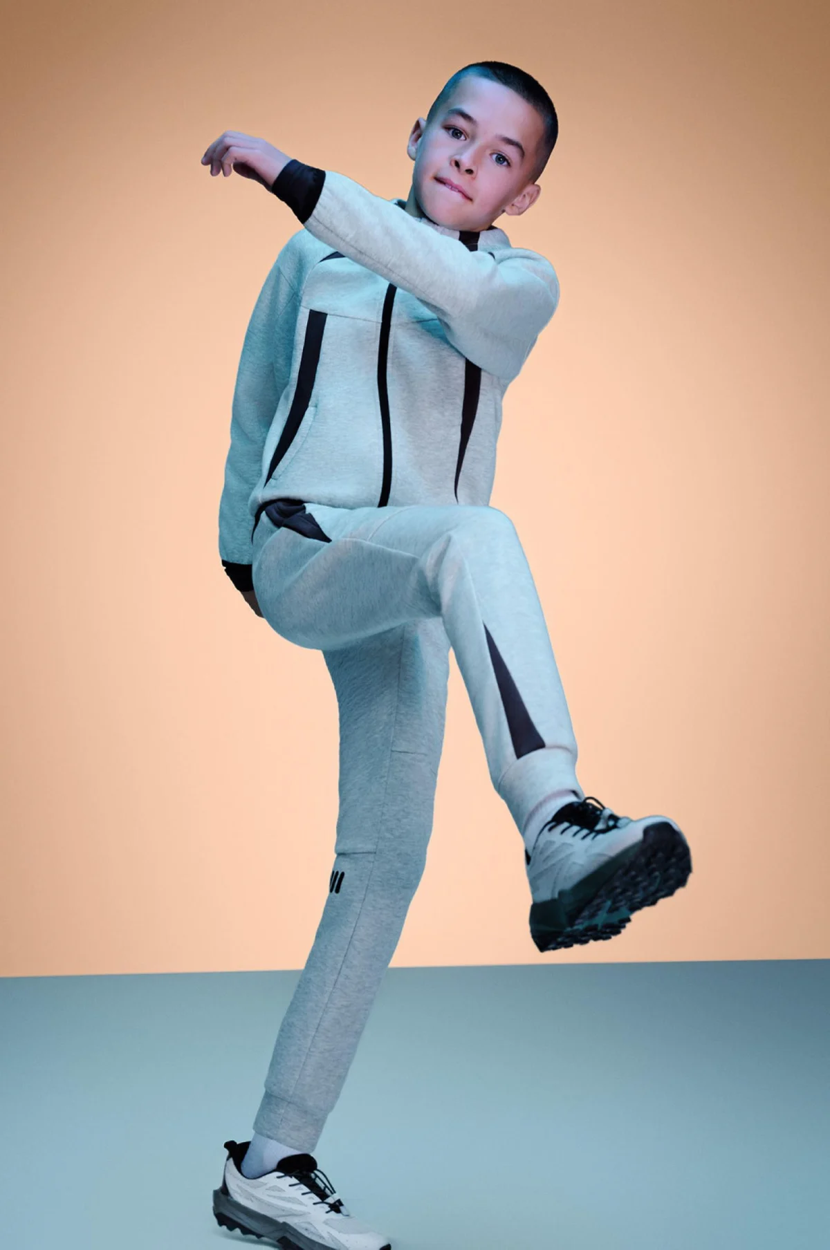 A boy posing in a grey Primark tracksuit and trainers