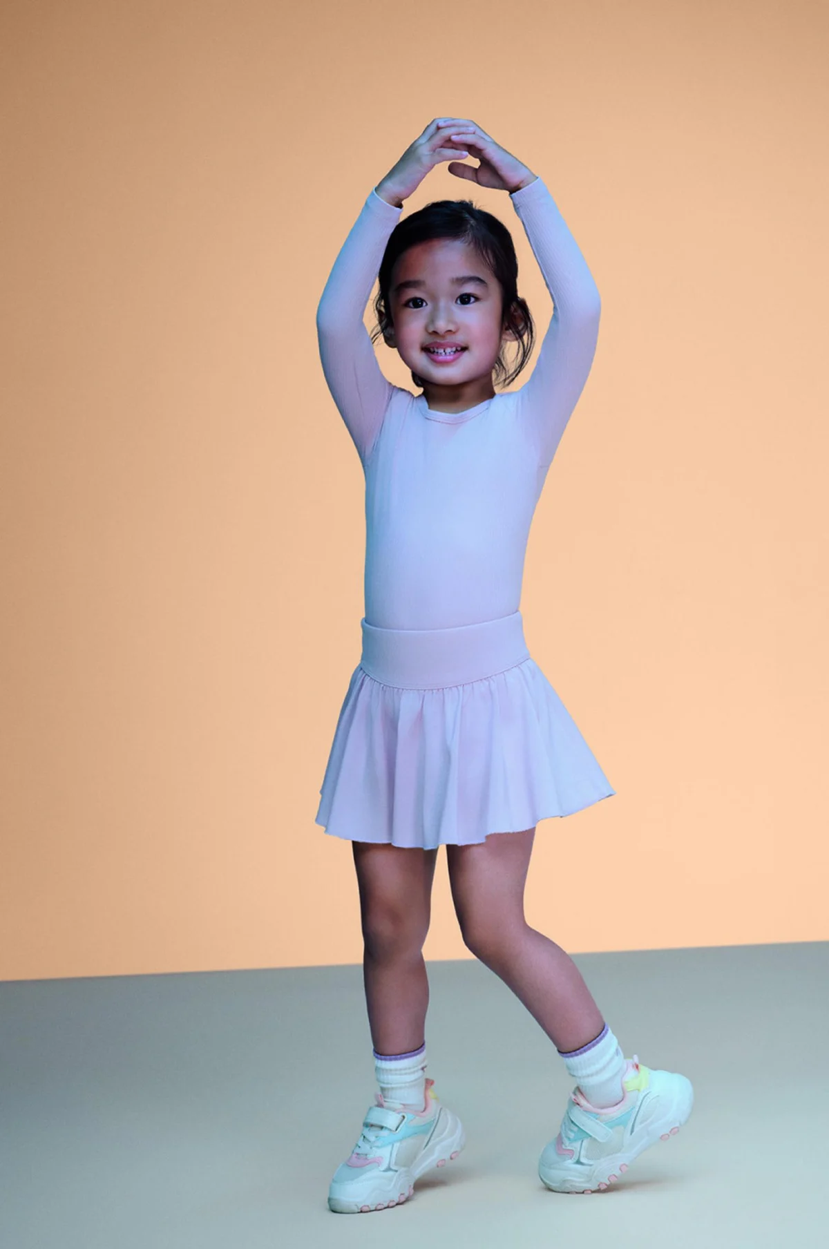 A girl posing in a lilac Primark activewear set and trainers