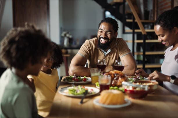 A family laughing together over a home-cooked meal at the dining table